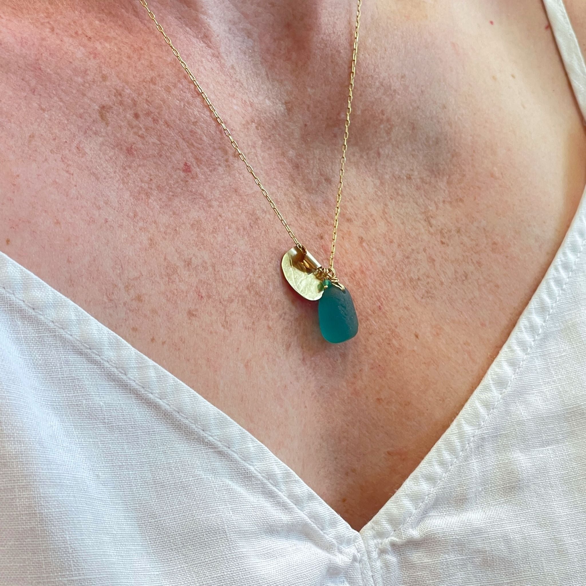 Handcrafted teal sea glass necklace on white background