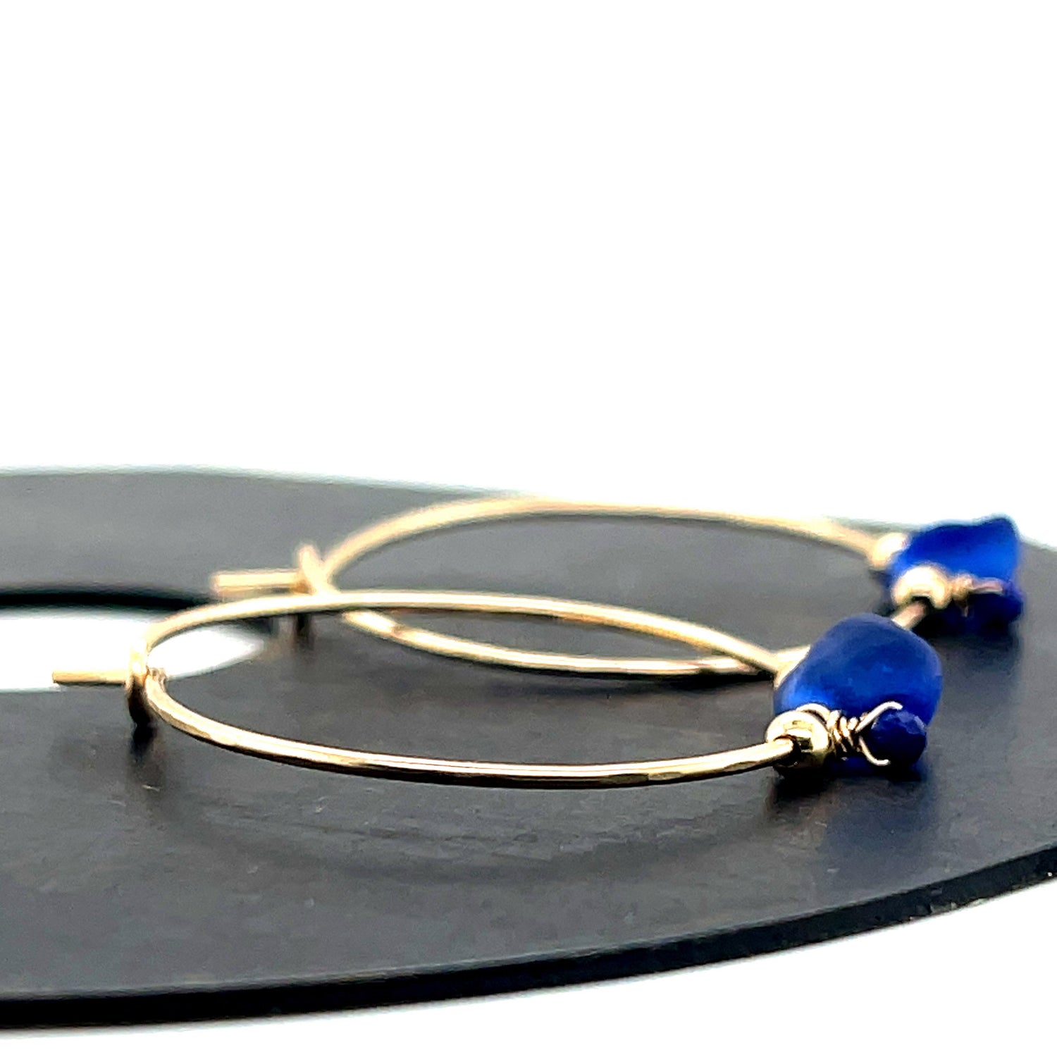 Artisanal hammered gold hoops with cobalt blue sea glass nuggets and tiny lapis lazuli beads