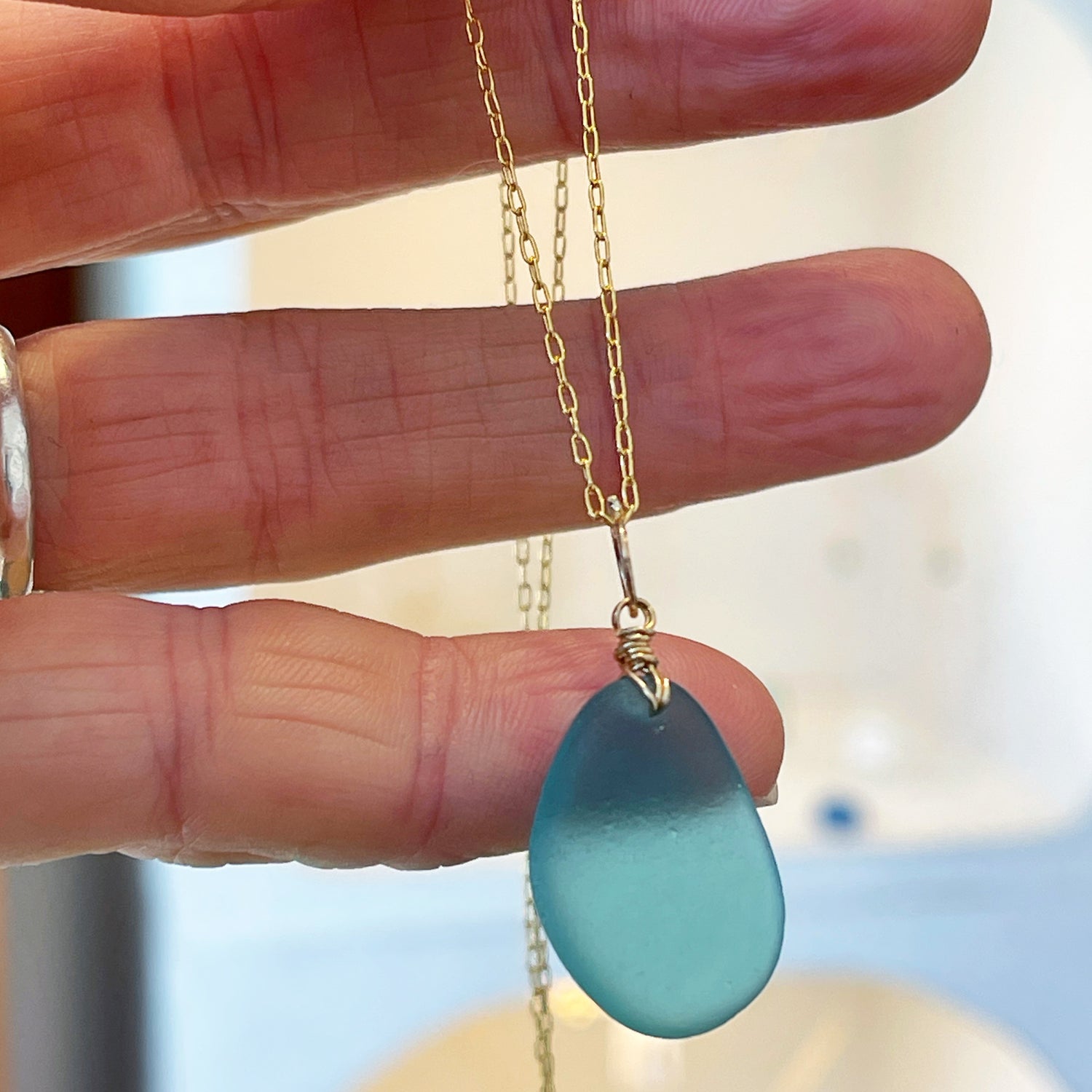 Handcrafted turquoise sea glass nugget from Japan on a gold bail and elongated trace chain