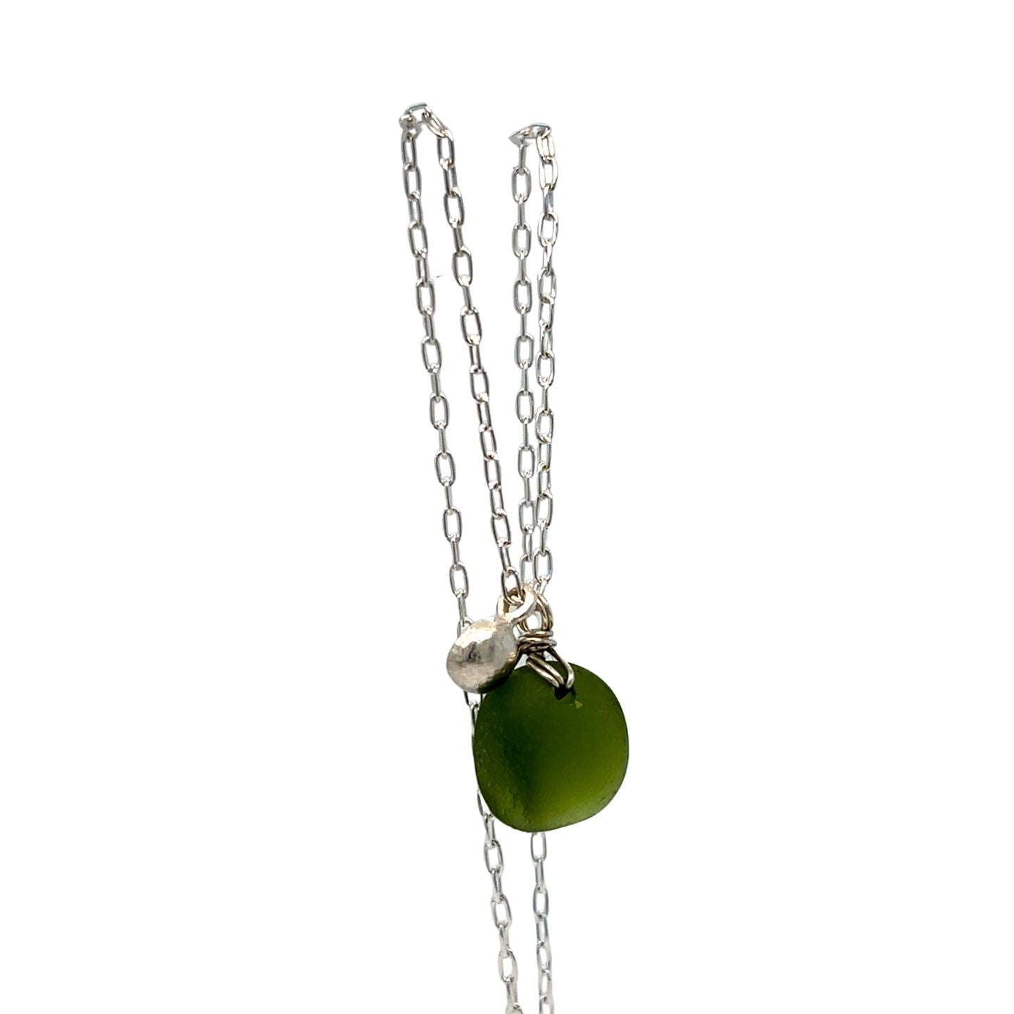 Close-up of green sea glass pendant and silver detail